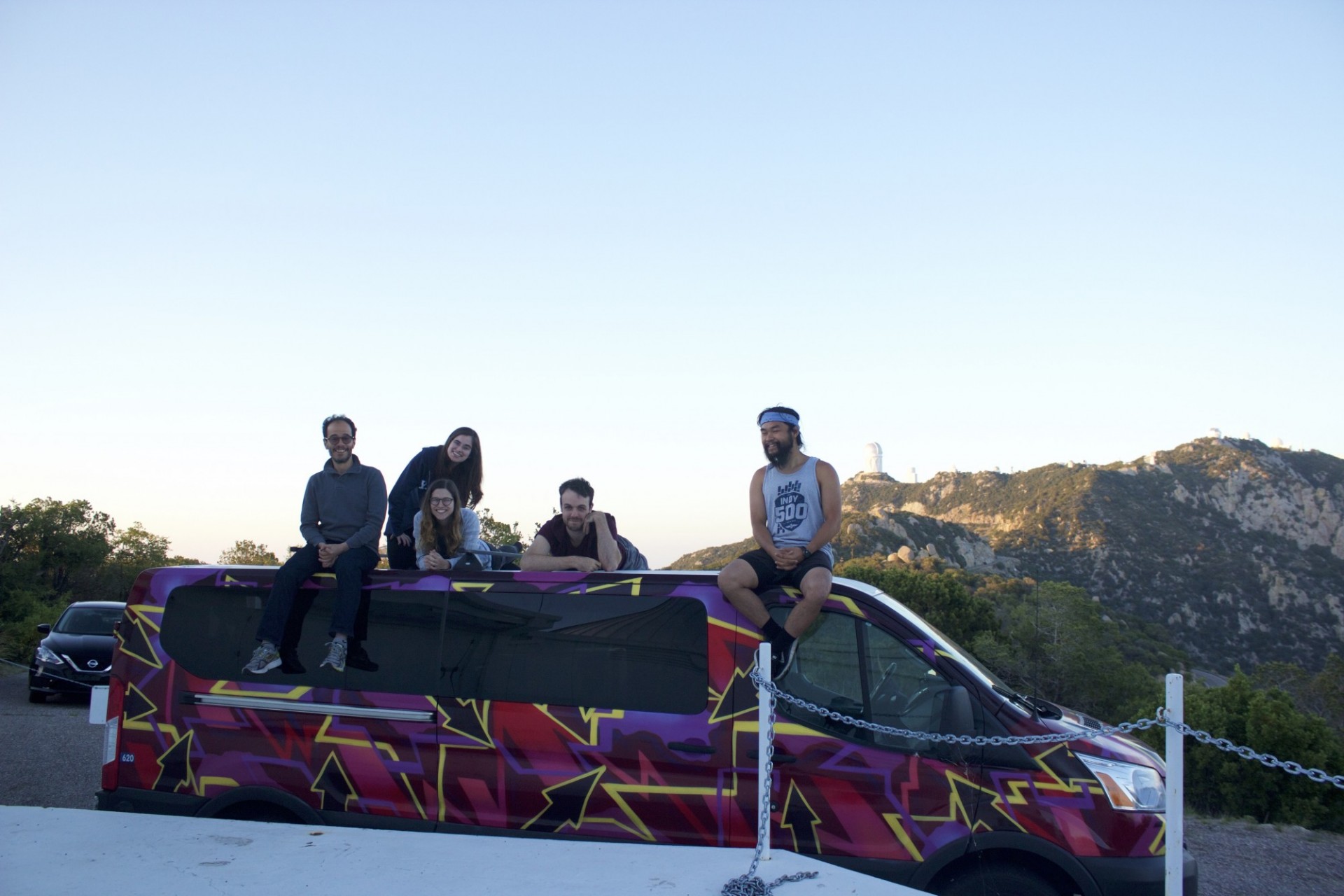 Group on top of a multicolored van with Kitt Peak as background, as seen from the MDM Observatory.